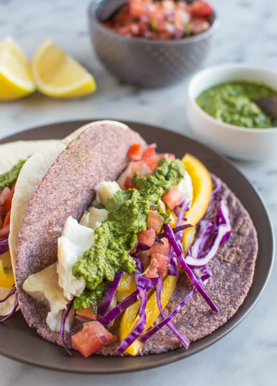 Delicious fish tacos with a spicy and tangy green harissa. Add some spice to your dinner or lunch with these healthy tacos! | healthynibblesandbits.com