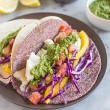 Delicious fish tacos with a spicy and tangy green harissa. Add some spice to your dinner or lunch with these healthy tacos! | healthynibblesandbits.com