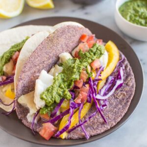Delicious fish tacos with a spicy and tangy green harissa. Add some spice to your dinner or lunch with these healthy tacos! | healthynibblesandbits.com