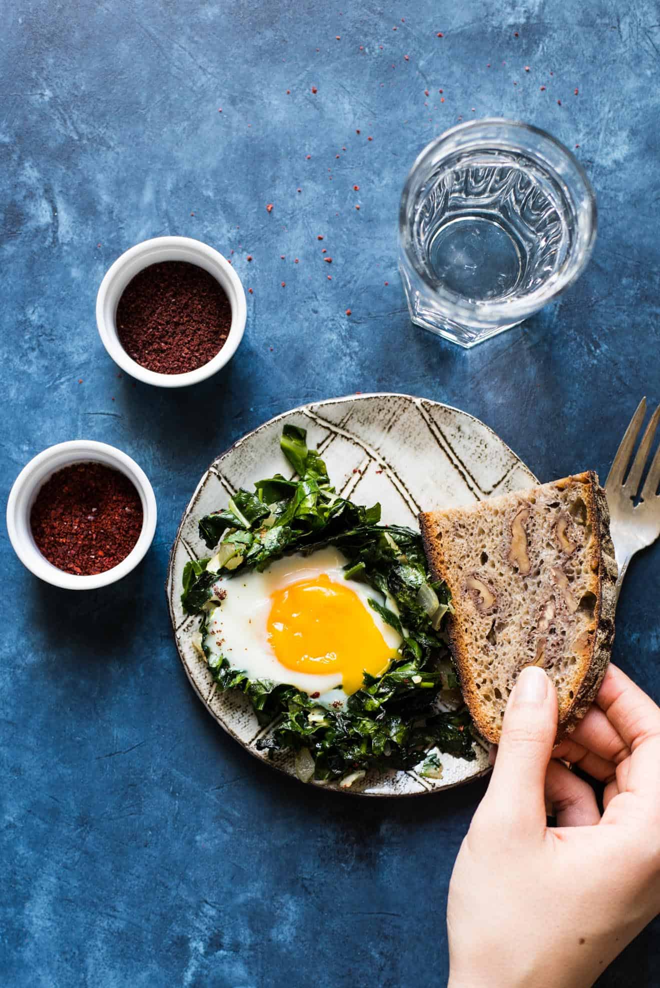 Green Shakshuka - a healthy breakfast dish filled with kale, collard greens and sunny side up eggs. An easy gluten-free meal!