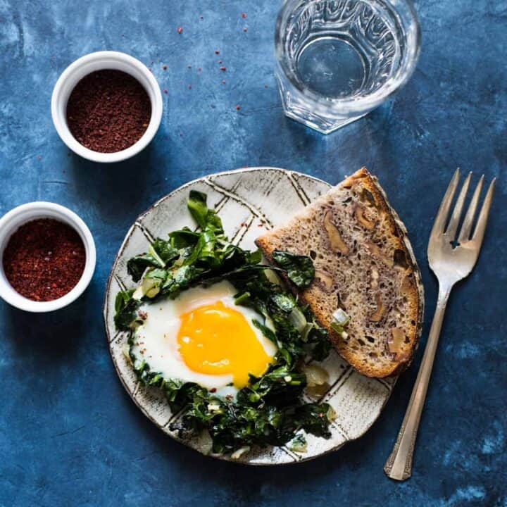 Green Shakshuka - a healthy breakfast dish filled with kale, collard greens and sunny side up eggs. An easy gluten-free meal!