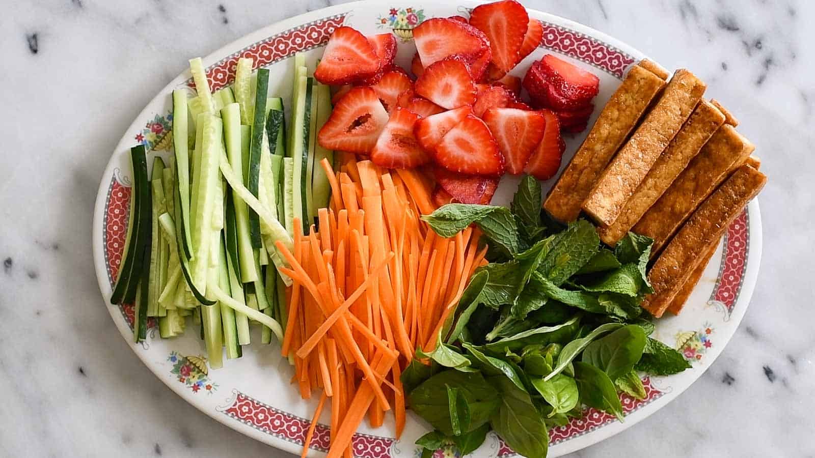 Filling for spring rolls: cucumber, carrots, strawberries, teriyaki tofu, mint, and basil