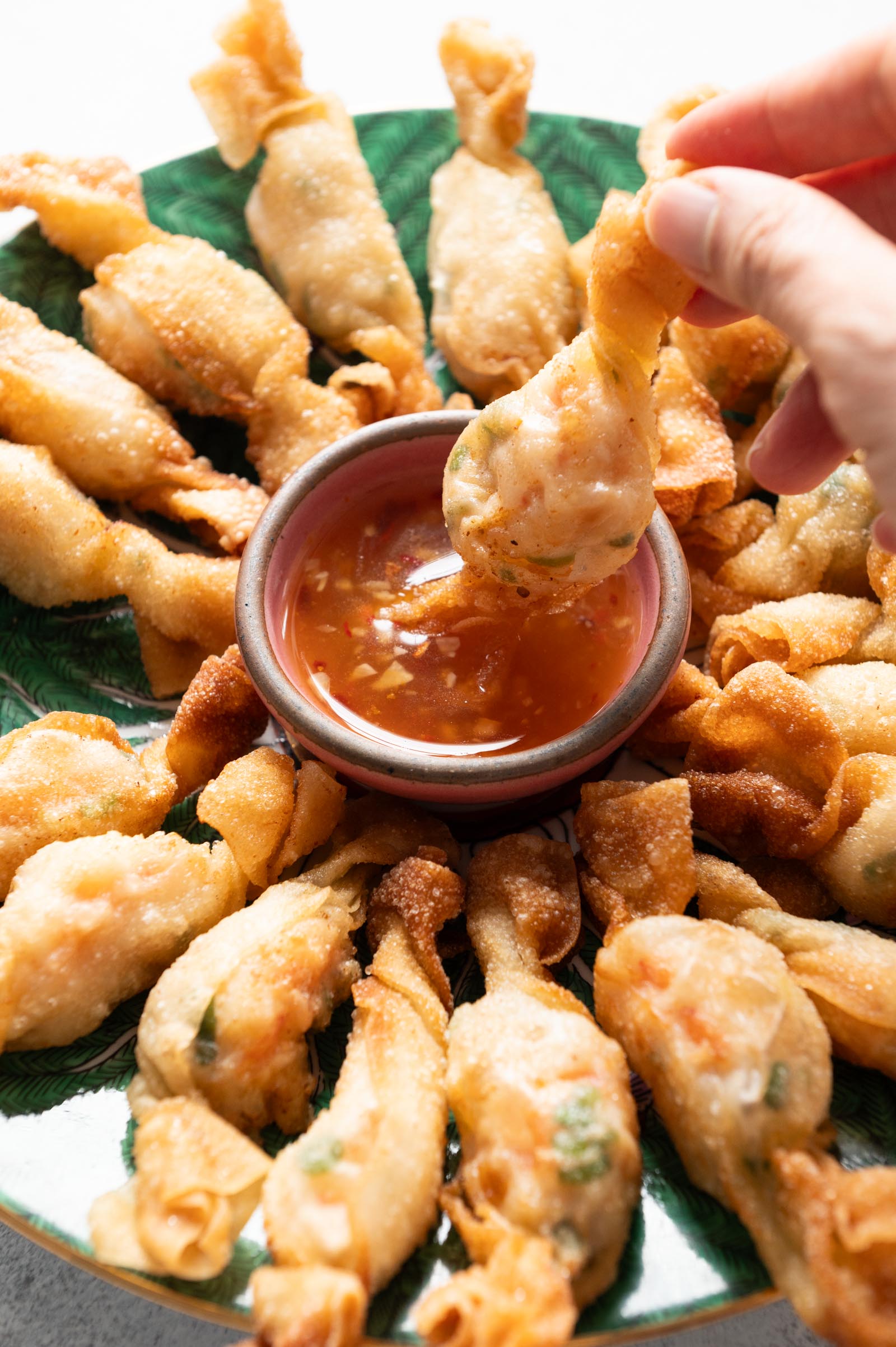 Dipping wonton into sweet chili sauce